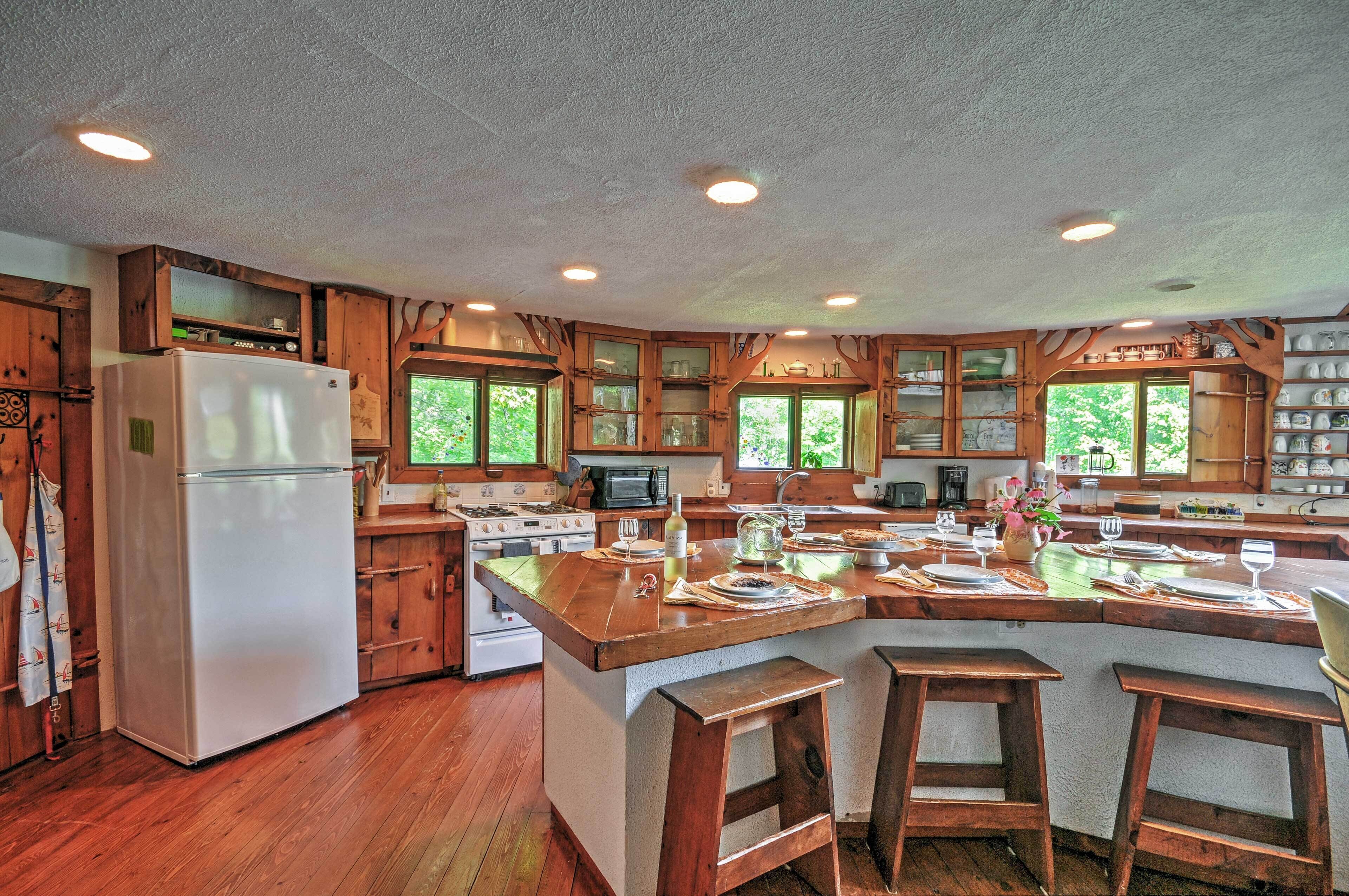 A spacious kitchen with wooden cabinets, a central island, and a large refrigerator.