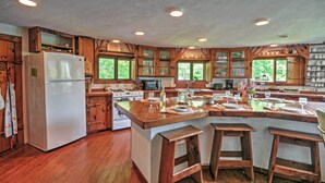 A spacious kitchen with wooden cabinets, a central island, and a large refrigerator. - 'dragonwood Castle' on Waterfront w/ Stunning View (Prospect Harbor)