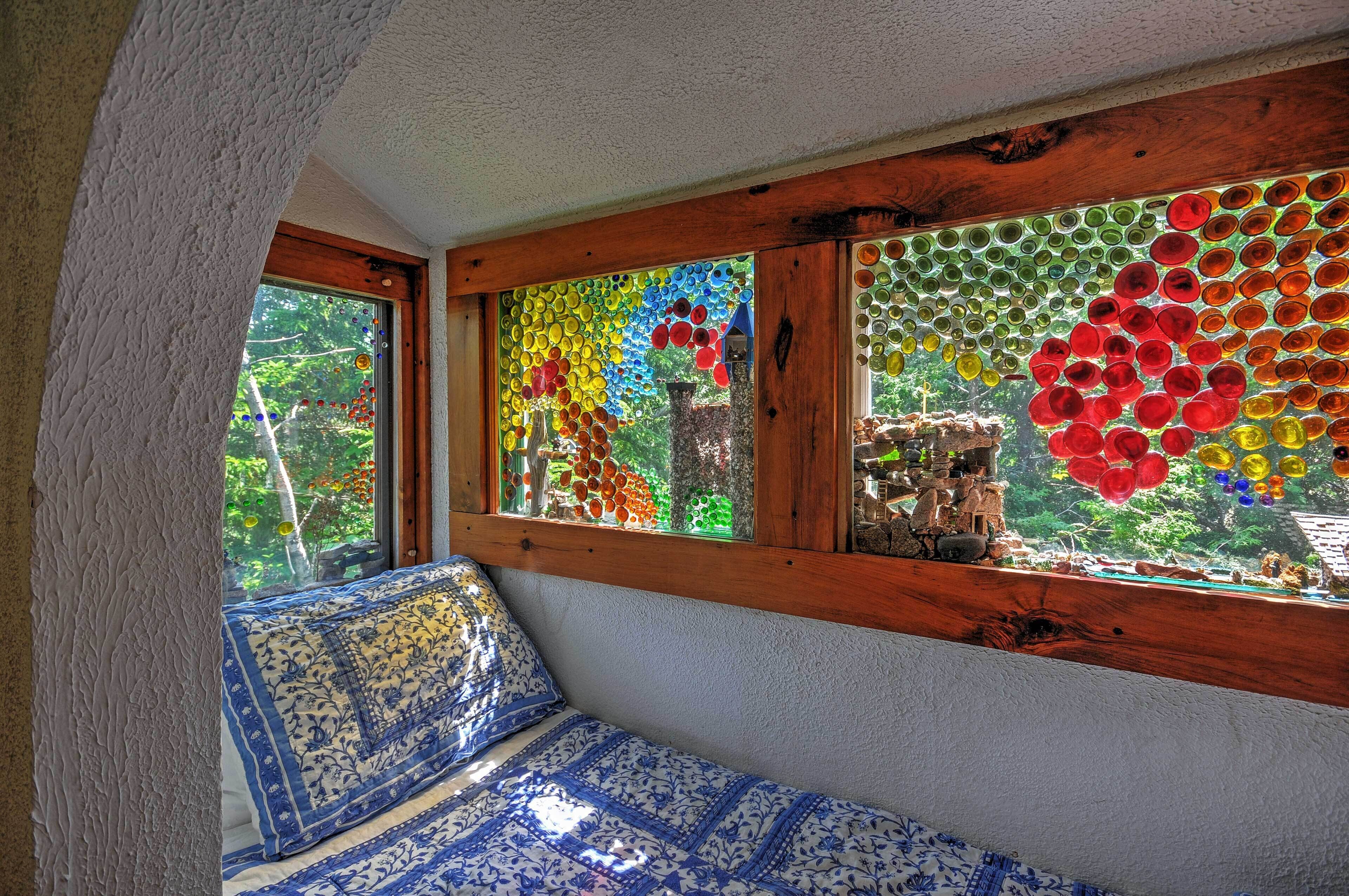A room with a wooden bench and a window with colorful glass art.