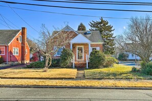 A two-story house with a brick facade, a red door, and a small front porch.