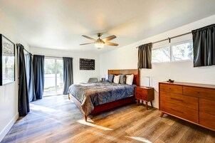 Un dormitorio con cama, cómoda de madera y ventilador de techo.