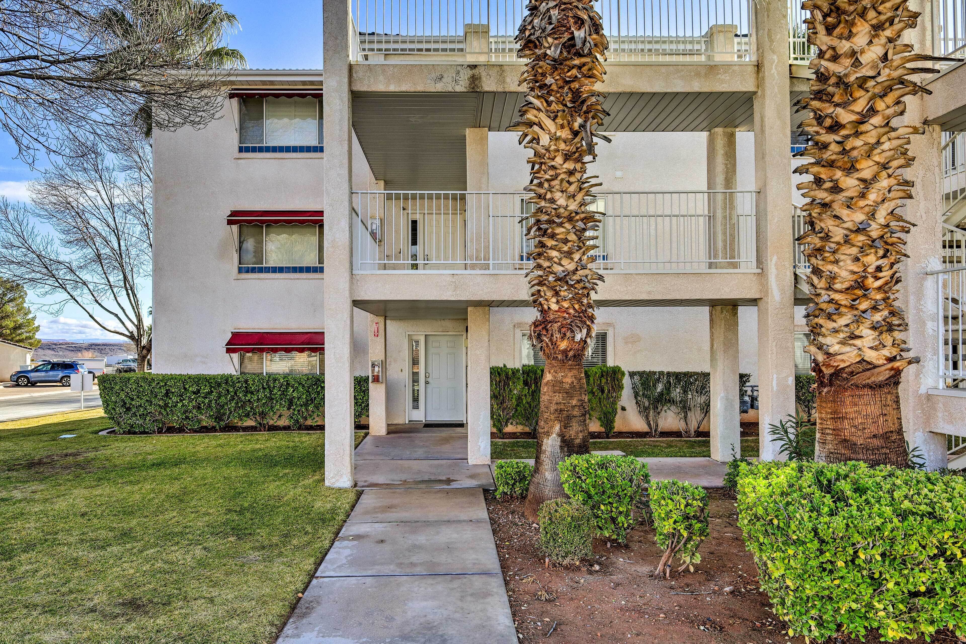 A multi-story building with a central courtyard, featuring a palm tree and well-maintained landscaping.