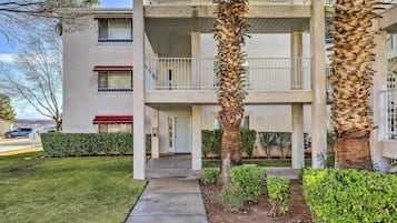 A multi-story building with a central courtyard, featuring a palm tree and well-maintained landscaping.