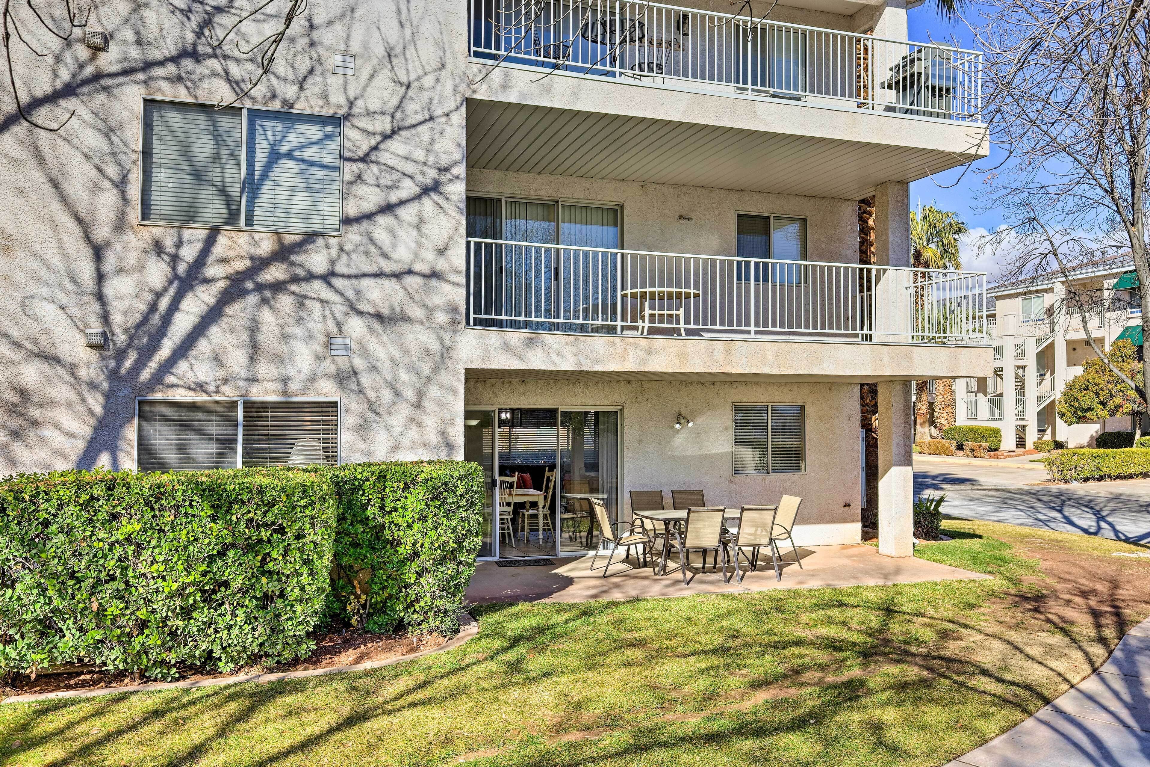 A multi-story residential building with a patio area featuring outdoor furniture.