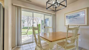 A dining area with a wooden table and four chairs, large sliding glass doors leading to a patio, and a ceiling light fixture. - Beautiful St George Condo ~ 5 Mi to Downtown! (St. George)