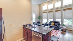 A modern kitchen with a central island, dark wood cabinets, and a stainless steel dishwasher.