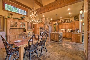 Una cocina amplia con armarios de madera, una chimenea de piedra y un comedor con mesa y sillas de madera.
