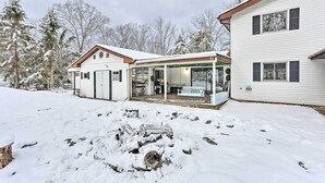 A two-story house with a covered porch and a snow-covered yard. - Large Greeley House w/ 2 Game Rooms + Yard! (Greeley)