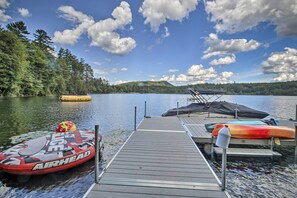 A wooden dock with kayaks and an inflatable boat.