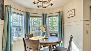 A dining area with a round table, four chairs, and a vase with dried plants. - Idyllic Pinehurst Home, Near Golf Course! (Pinehurst)