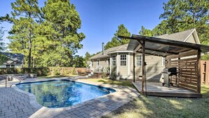 A backyard with a swimming pool, a covered patio, and a barbecue area. - Idyllic Pinehurst Home, Near Golf Course! (Pinehurst)