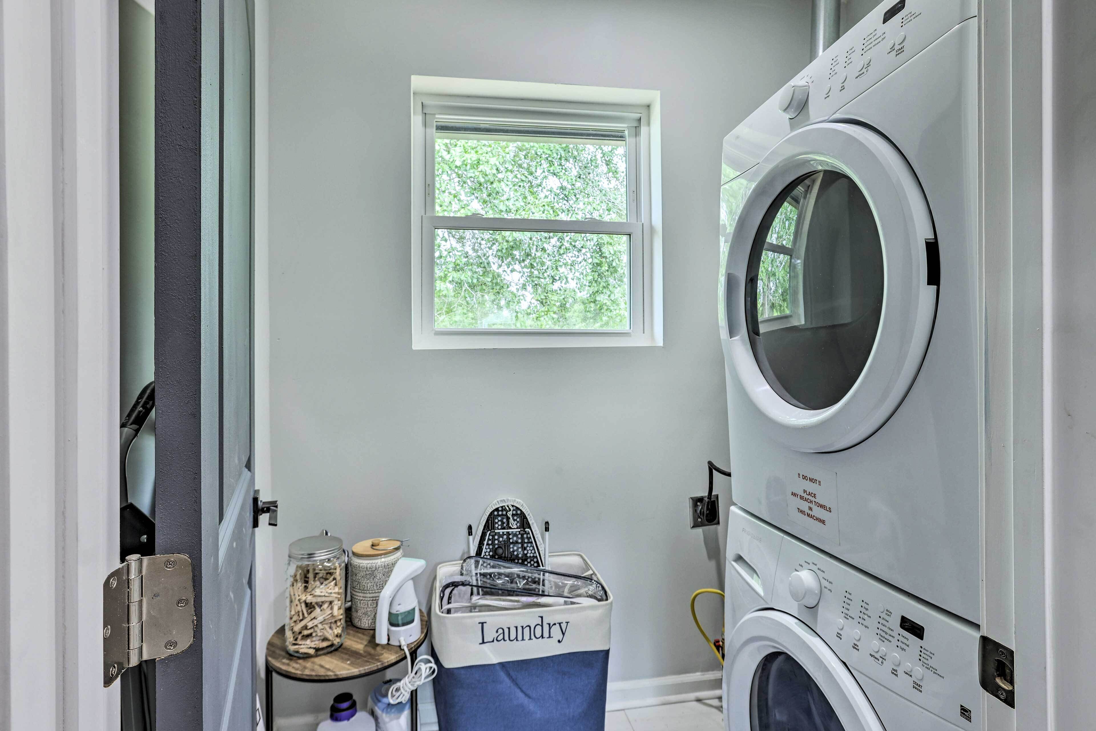A laundry room with a washing machine, a dryer, a window, and a laundry basket labeled "Laundry".