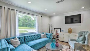 A modern living room with a teal sofa, a round coffee table, and a grey armchair. - Modern, Colorful Home ~ 2 Mi to Tuskegee Uni (Tuskegee)