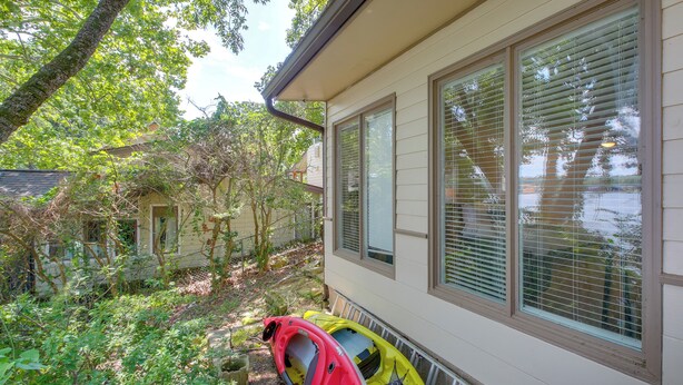 A house with a covered porch and two kayaks, one red and one yellow, parked outside. - Boat Dock, Personal Watercraft: Lake Hamilton Home (Hot Springs)