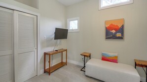 A bedroom with a bed, a TV on a stand, a window, and a painting on the wall. - Boat Dock, Personal Watercraft: Lake Hamilton Home (Hot Springs)