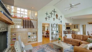 A spacious living room with a fireplace, a staircase, and a kitchen in the background. - Boat Dock, Personal Watercraft: Lake Hamilton Home (Hot Springs)