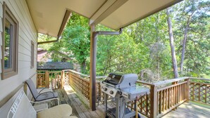 A covered deck with a grill, outdoor furniture, and a view of trees. - Boat Dock, Personal Watercraft: Lake Hamilton Home (Hot Springs)