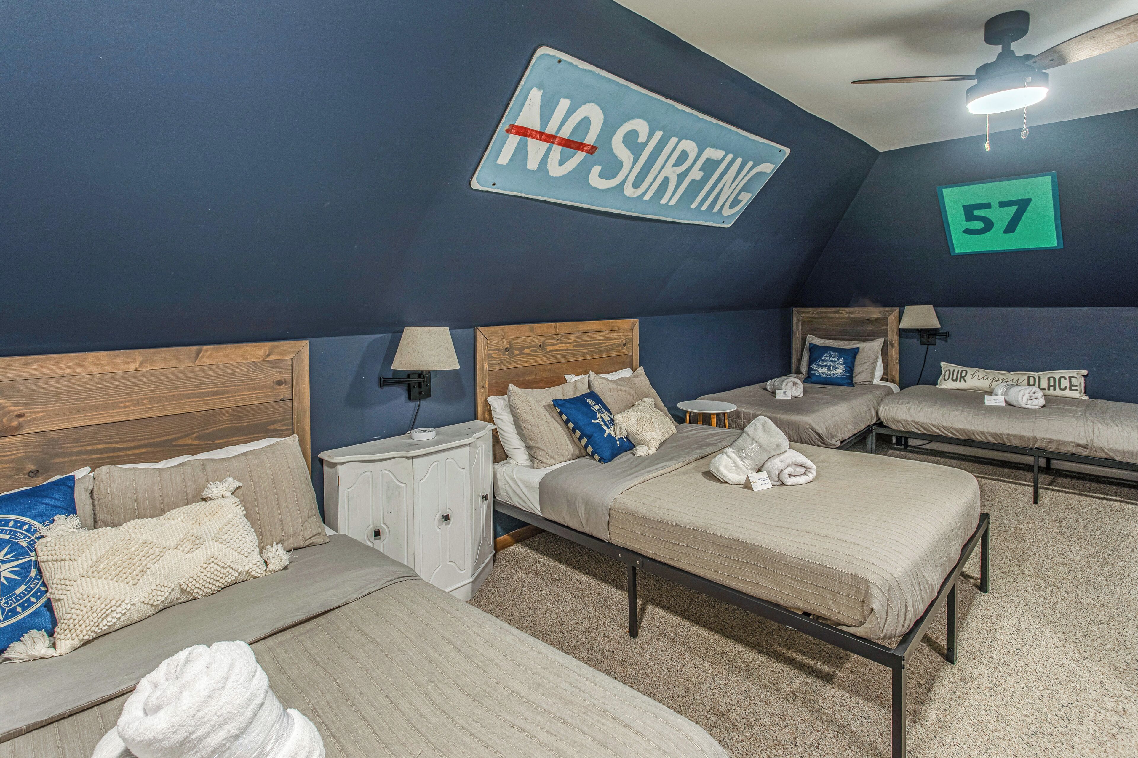 A hotel room with multiple beds, a 'NO SURFING' sign, and a number '57' on the wall.