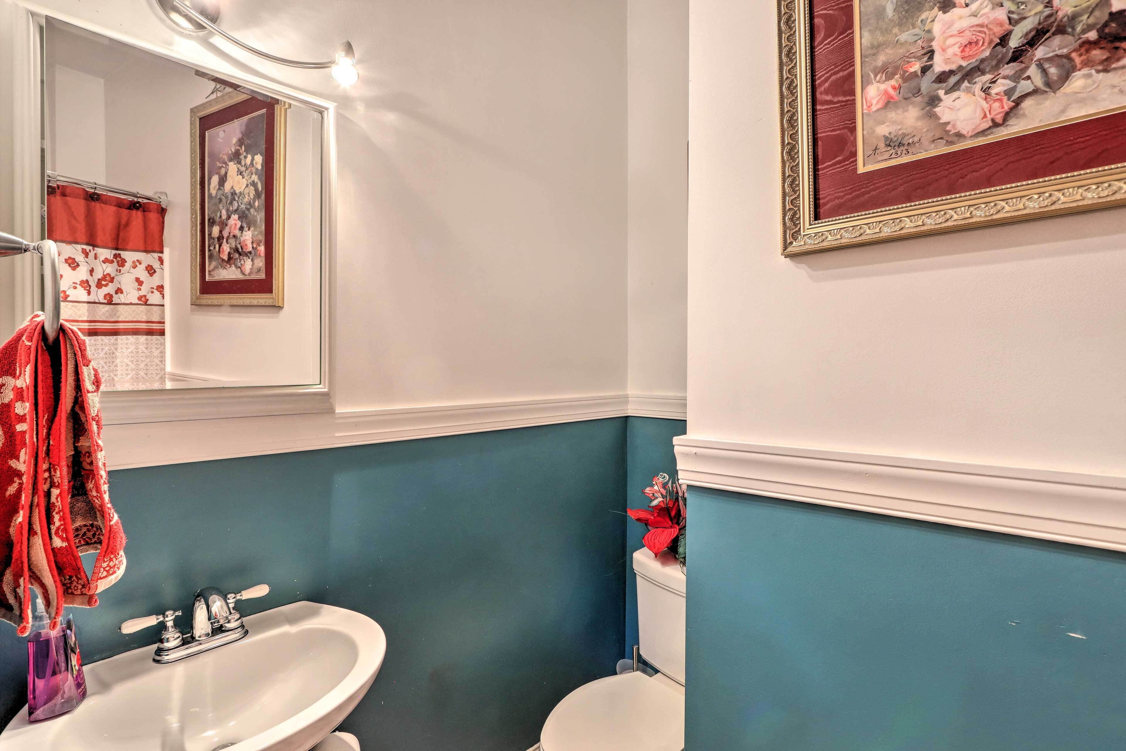 A bathroom with a white sink, a toilet, and a mirror.