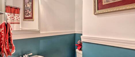 A bathroom with a white sink, a toilet, and a mirror.