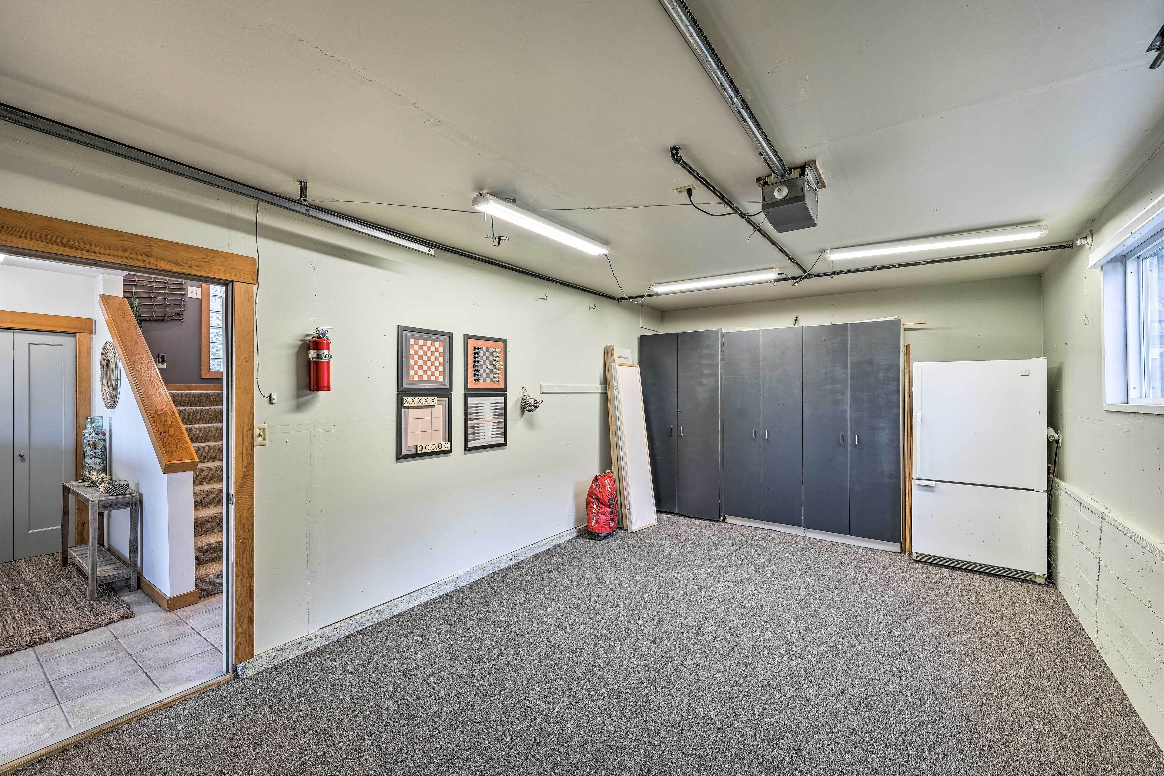 A spacious room with a carpeted floor, a wooden staircase, and a door leading to another area.