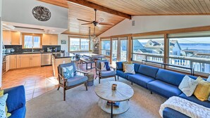 A spacious living area with a large sofa, a coffee table, and a dining area. - Mckees Beach House w/ Ocean Views, Hot Tub! (Stanwood)
