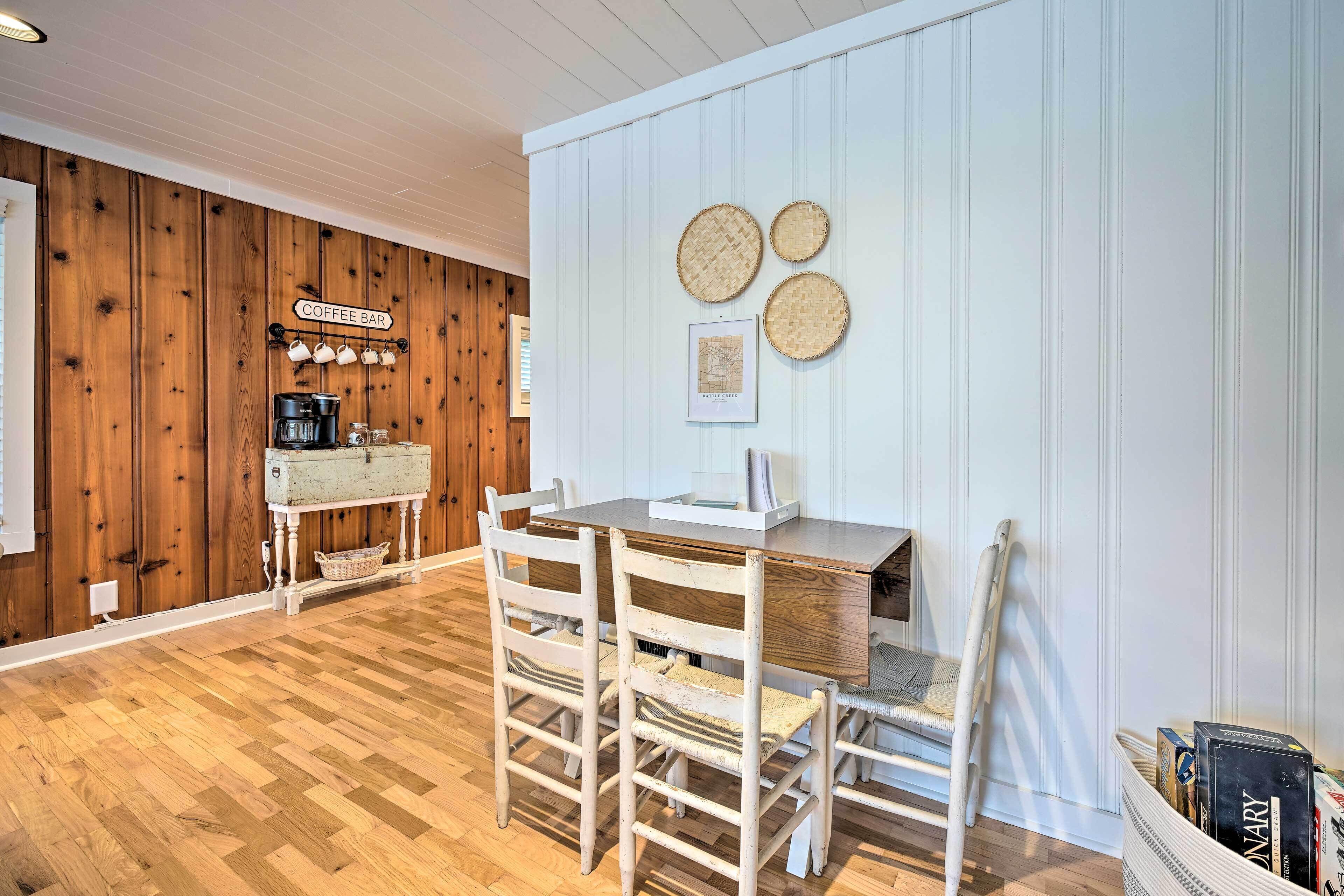 A dining area with a wooden table and chairs, a coffee bar, and wall-mounted woven baskets.