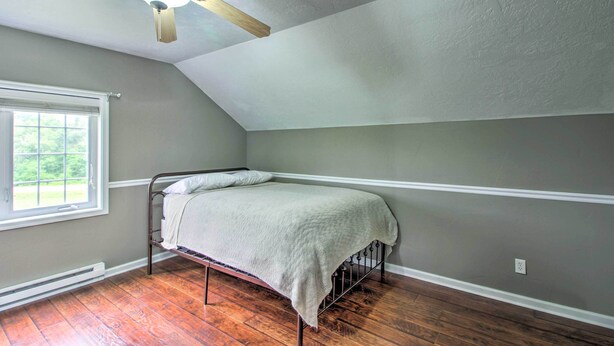 A bedroom with a bed, a window, a ceiling fan, and wooden flooring. - Quiet Retreat w/ Kayak & Patio, Walk to Lake! (Audubon)