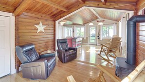 A cozy cabin interior with wooden walls, a fireplace, leather recliners, and a rocking chair. - Cozy Lake Champlain Cottage w/ Private Beach! (North Hero)