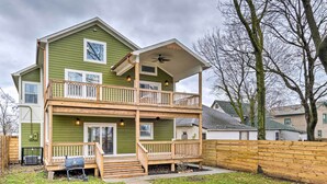 A two-story house with a front porch, a balcony on the upper floor, and a fenced yard. - Indianapolis Vacation Home: 3 Mi to Dtwn! (Indianapolis)