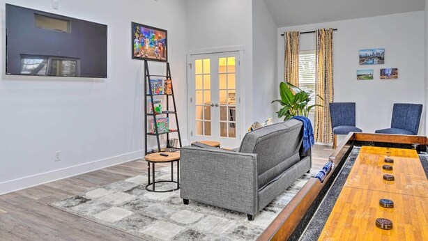 A modern living room with a sofa, a coffee table, and a bookshelf. - Indianapolis Vacation Home: 3 Mi to Dtwn! (Indianapolis)