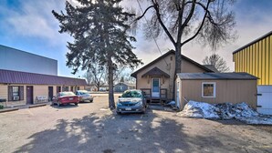 A parking lot with several cars, a small building with a door and windows, and a large tree. - Vacation Rental Near Boyd Lake, Colorado! (Loveland)