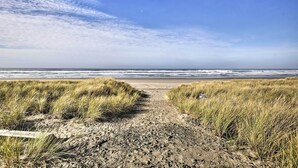 A beach path leading to the ocean with grassy dunes and a clear sky. - Private Rockaway Beach Retreat: 2 Blocks to Ocean! (Rockaway Beach)