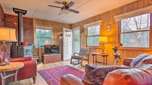 A cozy living room with a fireplace, leather sofa, and a television.