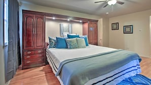 A bedroom with a large bed, wooden wardrobe, and a ceiling fan. - Home w/ Yard & Patio ~ 30 Mi to Downtown Chicago (Matteson)