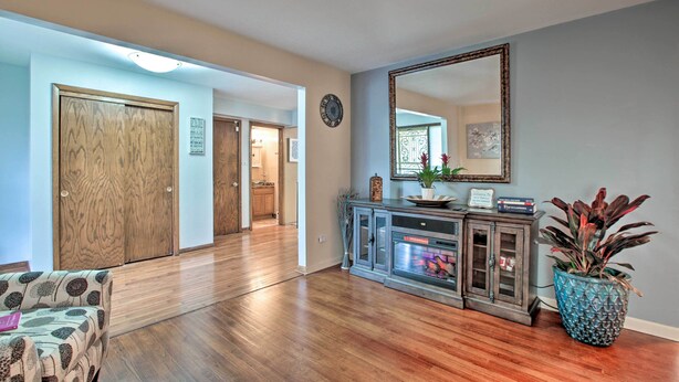 A spacious hallway with wooden flooring, a large mirror, and a potted plant. - Home w/ Yard & Patio ~ 30 Mi to Downtown Chicago (Matteson)