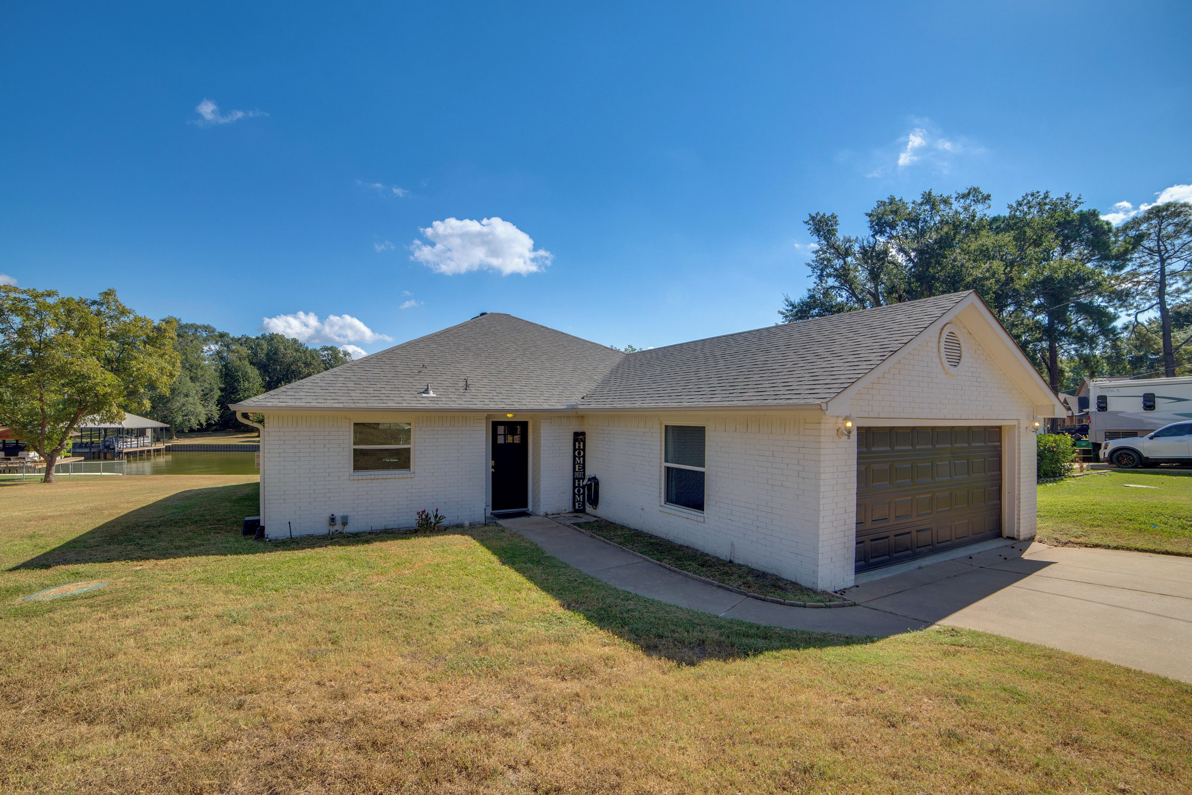 A single-story house with a garage, a front door, and a small front yard.