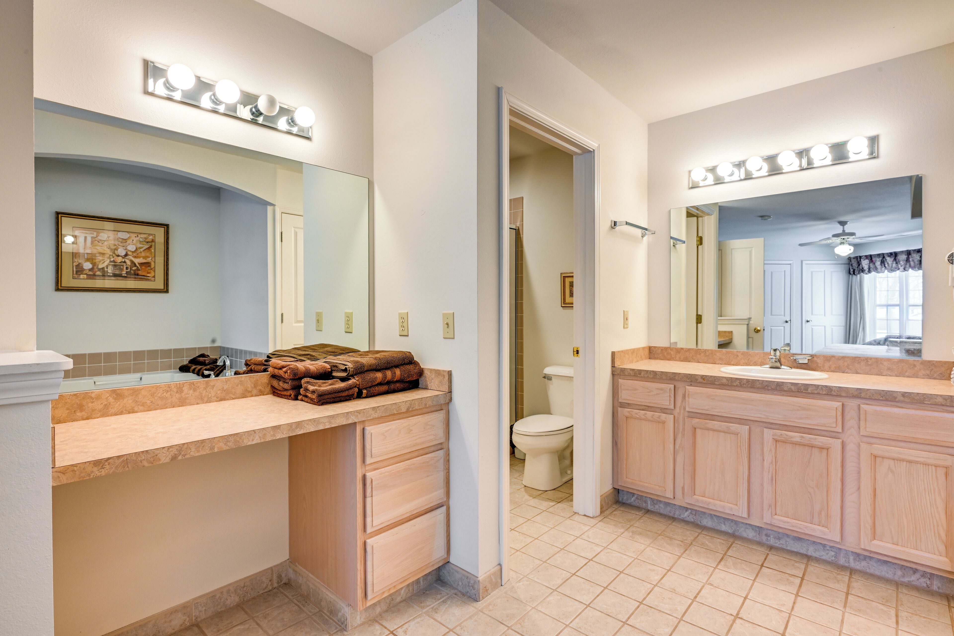 A bathroom with a vanity, a mirror, and a toilet.