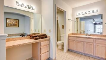 A bathroom with a vanity, a mirror, and a toilet.