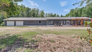A two-story building with a garage, a covered patio area, and a fenced yard.
