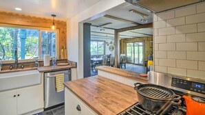Una cocina moderna con encimera de madera, electrodomésticos de acero inoxidable y un reloj digital que marca las 3:40.