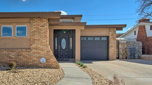 A modern two-story house with a brick facade, a dark front door, and a garage. - Modern El Paso Home w/ Backyard & Fire Pit! (El Paso)