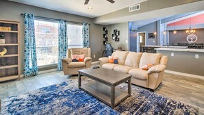 A living room with a ceiling fan, two sofas, a coffee table, and a rug. - Modern El Paso Home w/ Backyard & Fire Pit! (El Paso)