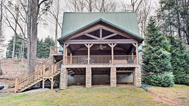 Un chalet doté d’une terrasse en bois, de piliers en pierre et d’un toit végétalisé.