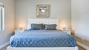A bedroom with a bed, two bedside tables, a nightstand, a mirror, and a ceiling fan. - Resort Pool & Hot Tub: Modern Condo in St George! (St. George)
