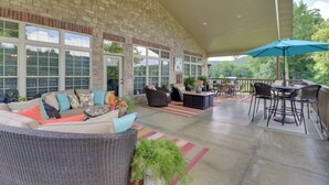 A covered patio area with wicker furniture, a dining table with chairs, and a large umbrella. - Mountain Home Gem on River! 0.4 Mi to Boat Launch (Mountain Home)