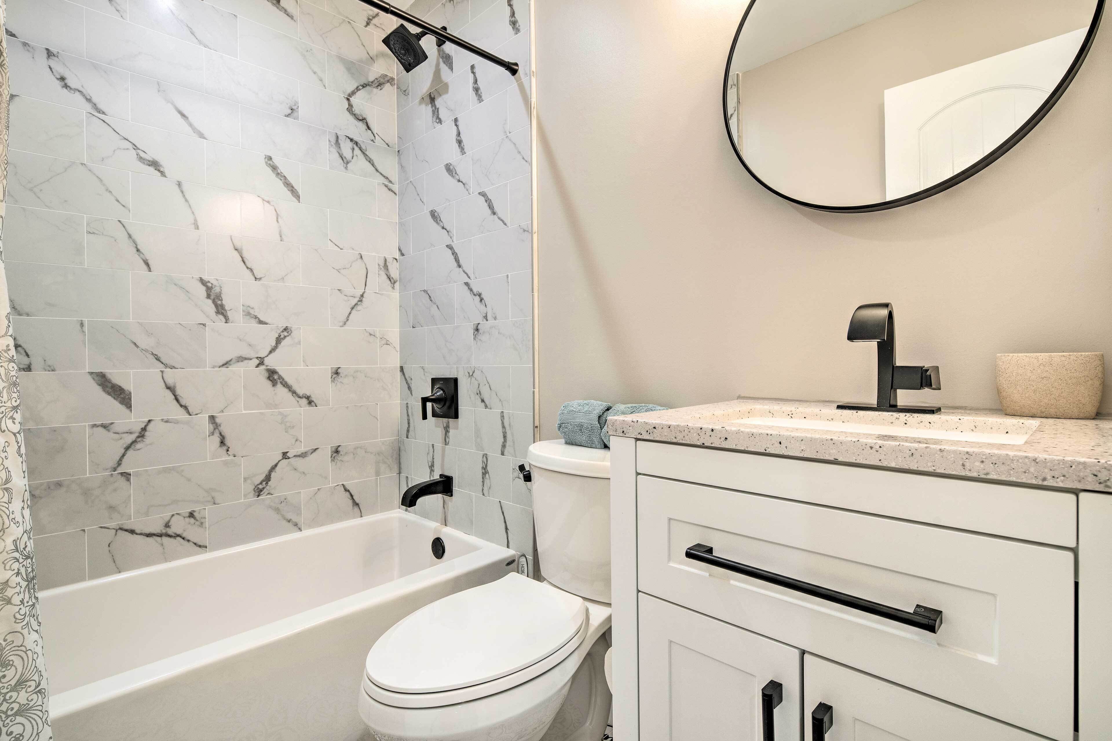 Une salle de bain avec une baignoire, des toilettes et un meuble-lavabo avec un miroir.