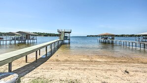 A beach with a wooden walkway leading to a small structure with a roof.