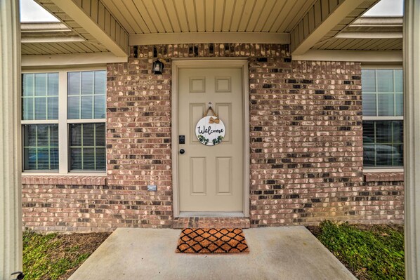 A brick house with a beige door, a welcome sign, and a doormat. - Quaint Family Home Near Downtown Murray & MSU (Murray)