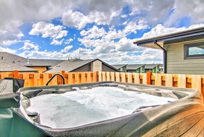 A hot tub in a backyard with a wooden fence and houses in the background. - Modern Bozeman Family Townhome w/ Hot Tub! (Bozeman)